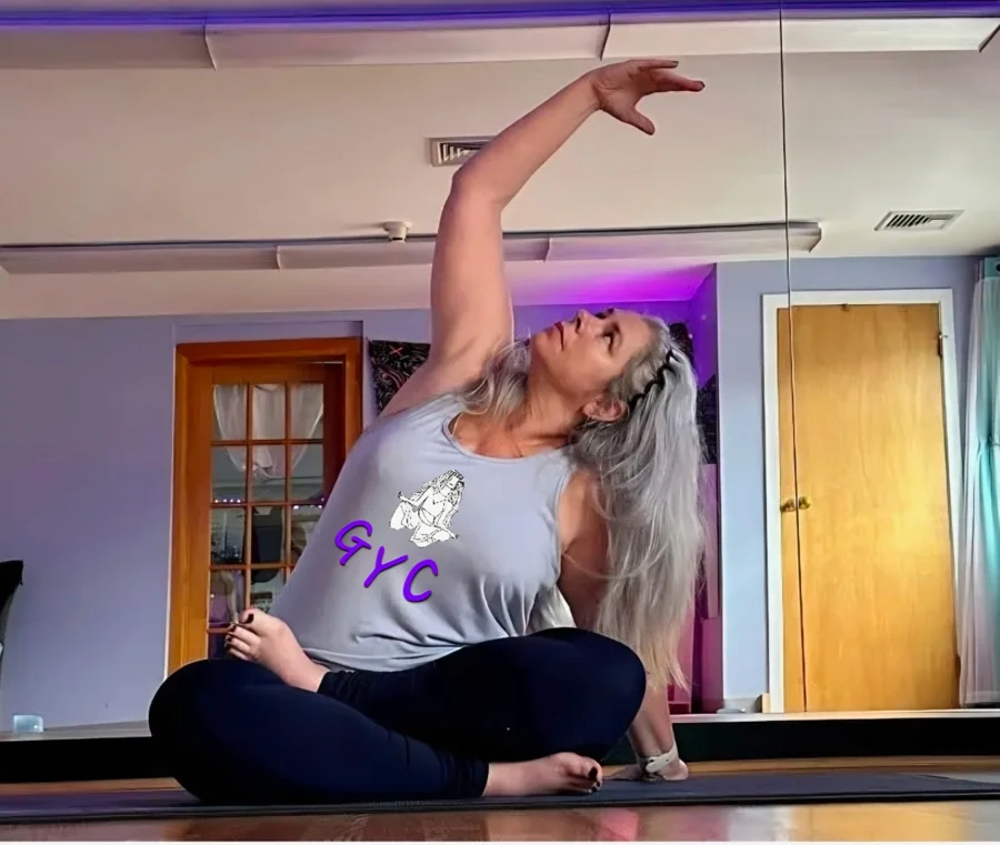 Tanya Andrade in a seated side stretch wearing a GYC tank